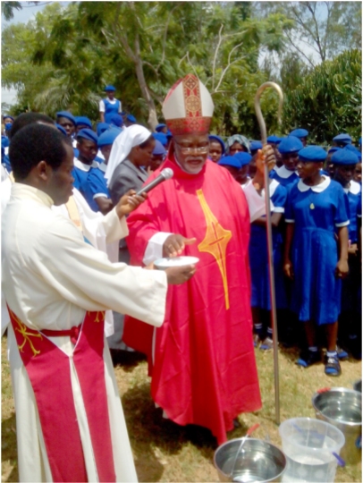 Bishop Avenya blesses water.